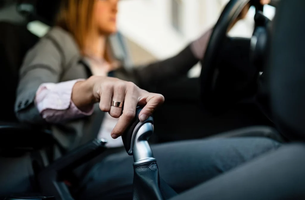 closeup of businesswoman driving car and shifting automatic transmission